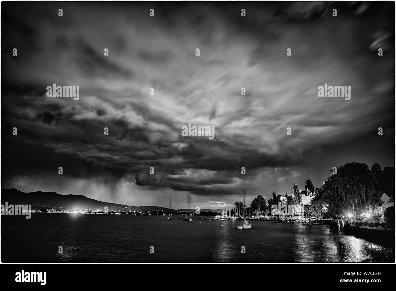 Orage au crépuscule sur Thoune. Le droit au Château Hünegg à Hilterfingen et à gauche 'Thuner Seespiele" Banque D'Images