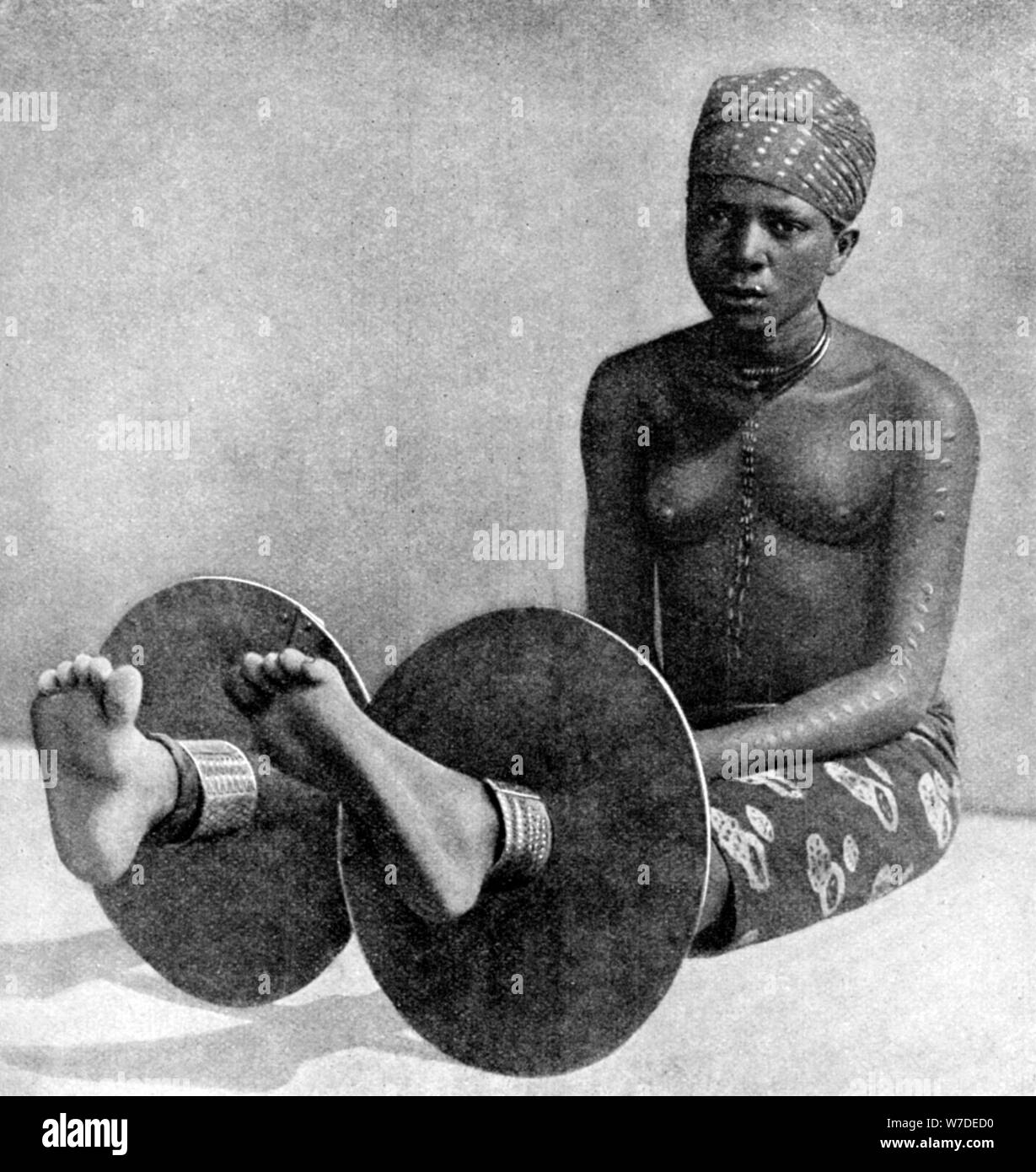 Une femme portant des plaques d'Ibos la cheville, le Nigeria, l'Afrique de l'Ouest, 1922.Artiste : Thomas Northcote Banque D'Images