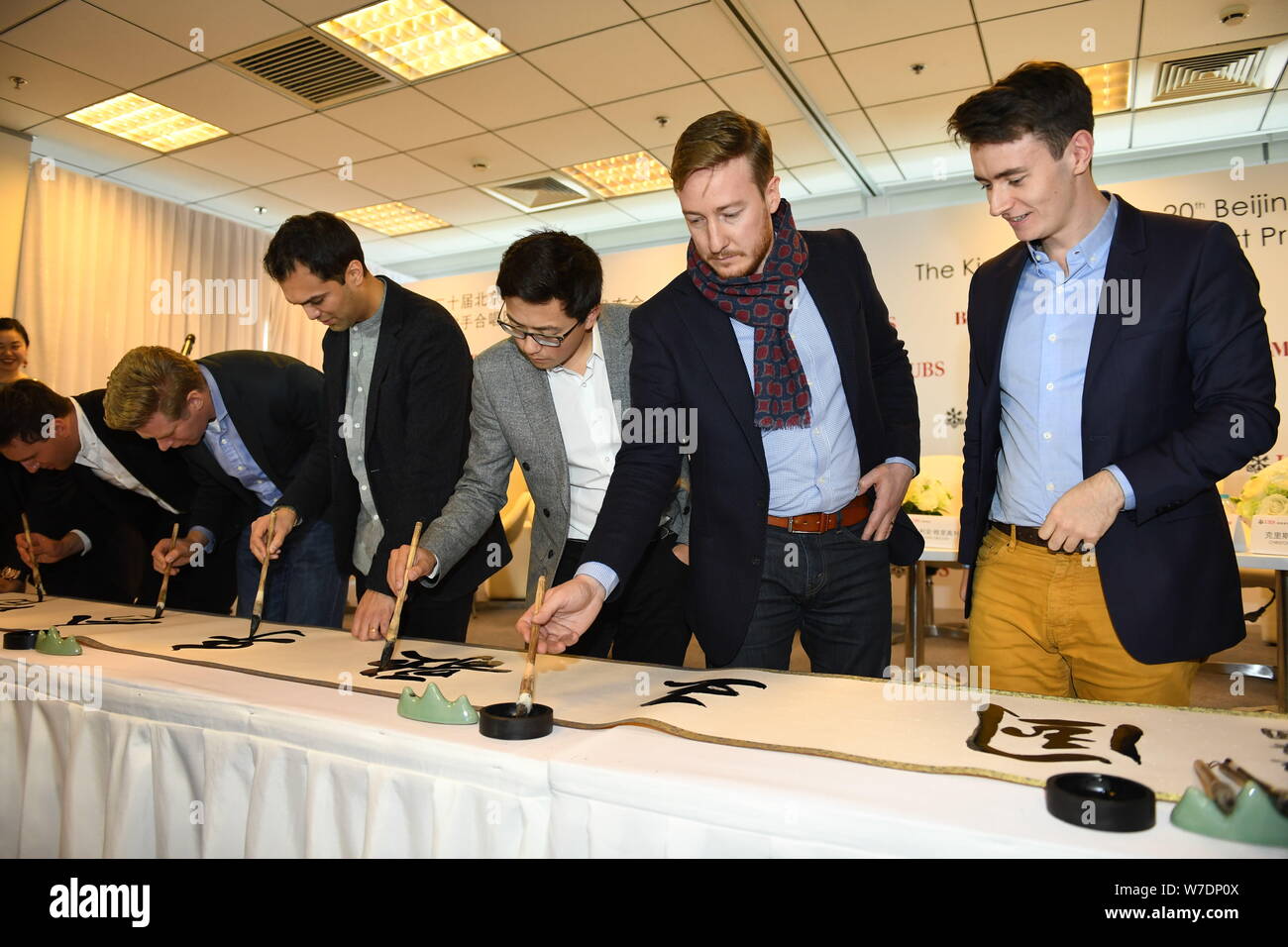 Les membres de l'ensemble vocal britannique King's Singers apprendre à écrire calligraphie chinoise lors d'une conférence de presse au cours de la fête de la musique de Beijing à Bei Banque D'Images