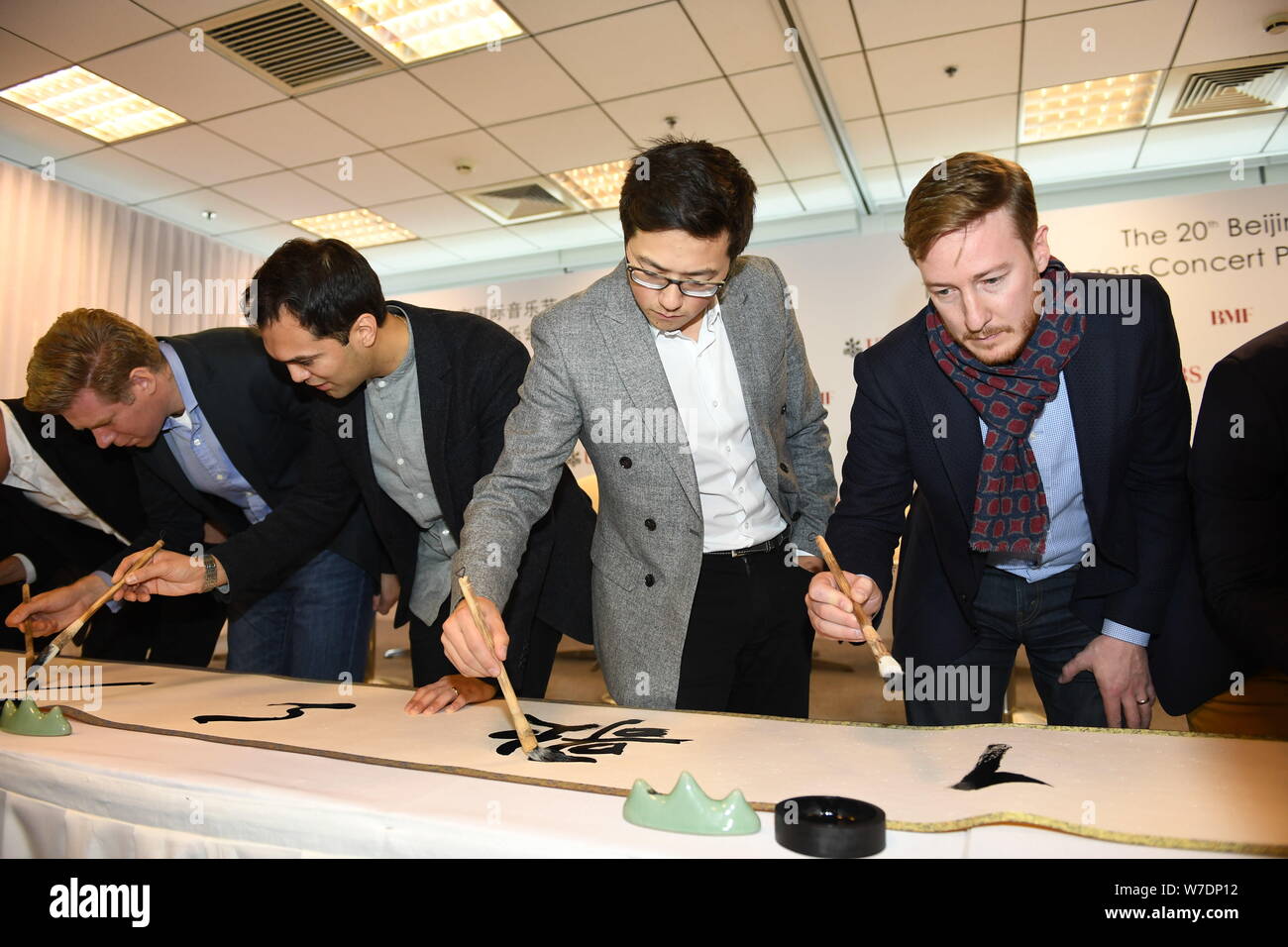Les membres de l'ensemble vocal britannique King's Singers apprendre à écrire calligraphie chinoise lors d'une conférence de presse au cours de la fête de la musique de Beijing à Bei Banque D'Images