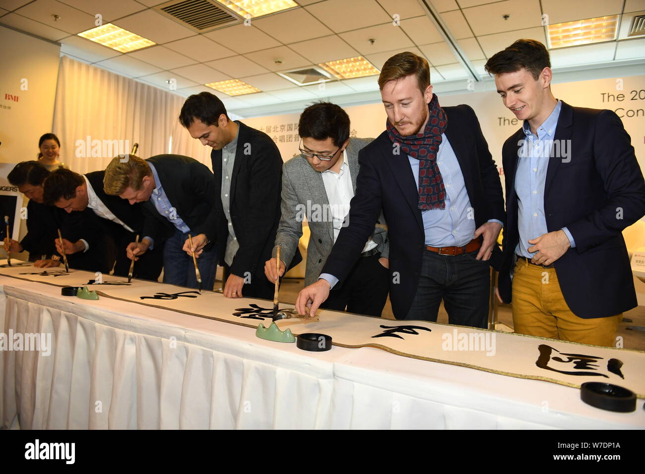 Les membres de l'ensemble vocal britannique King's Singers apprendre à écrire calligraphie chinoise lors d'une conférence de presse au cours de la fête de la musique de Beijing à Bei Banque D'Images
