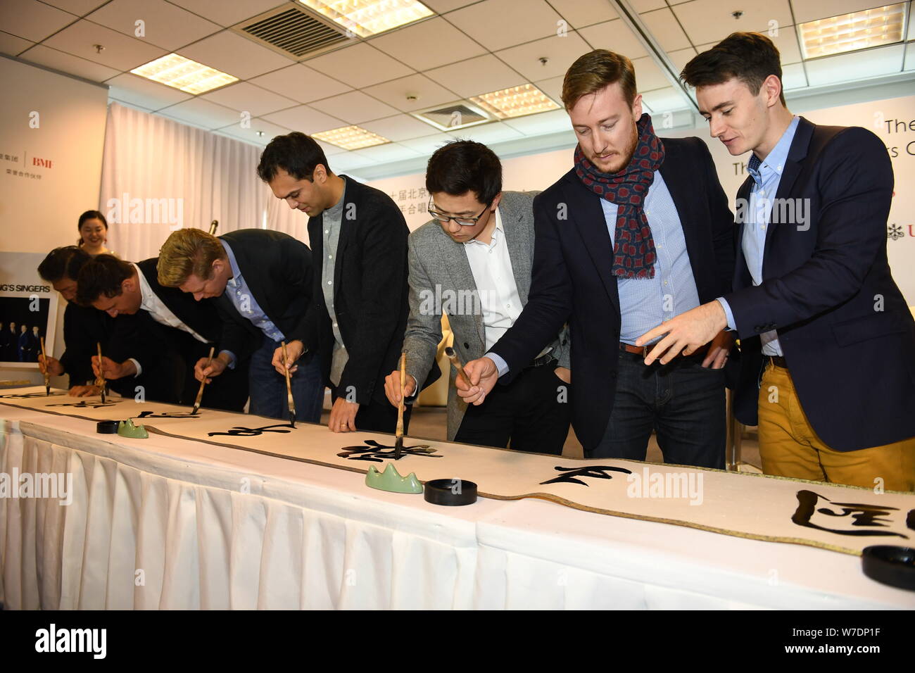Les membres de l'ensemble vocal britannique King's Singers apprendre à écrire calligraphie chinoise lors d'une conférence de presse au cours de la fête de la musique de Beijing à Bei Banque D'Images