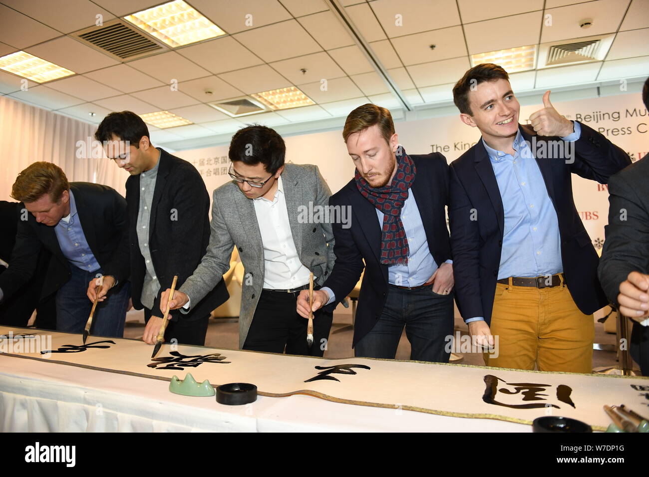 Les membres de l'ensemble vocal britannique King's Singers apprendre à écrire calligraphie chinoise lors d'une conférence de presse au cours de la fête de la musique de Beijing à Bei Banque D'Images