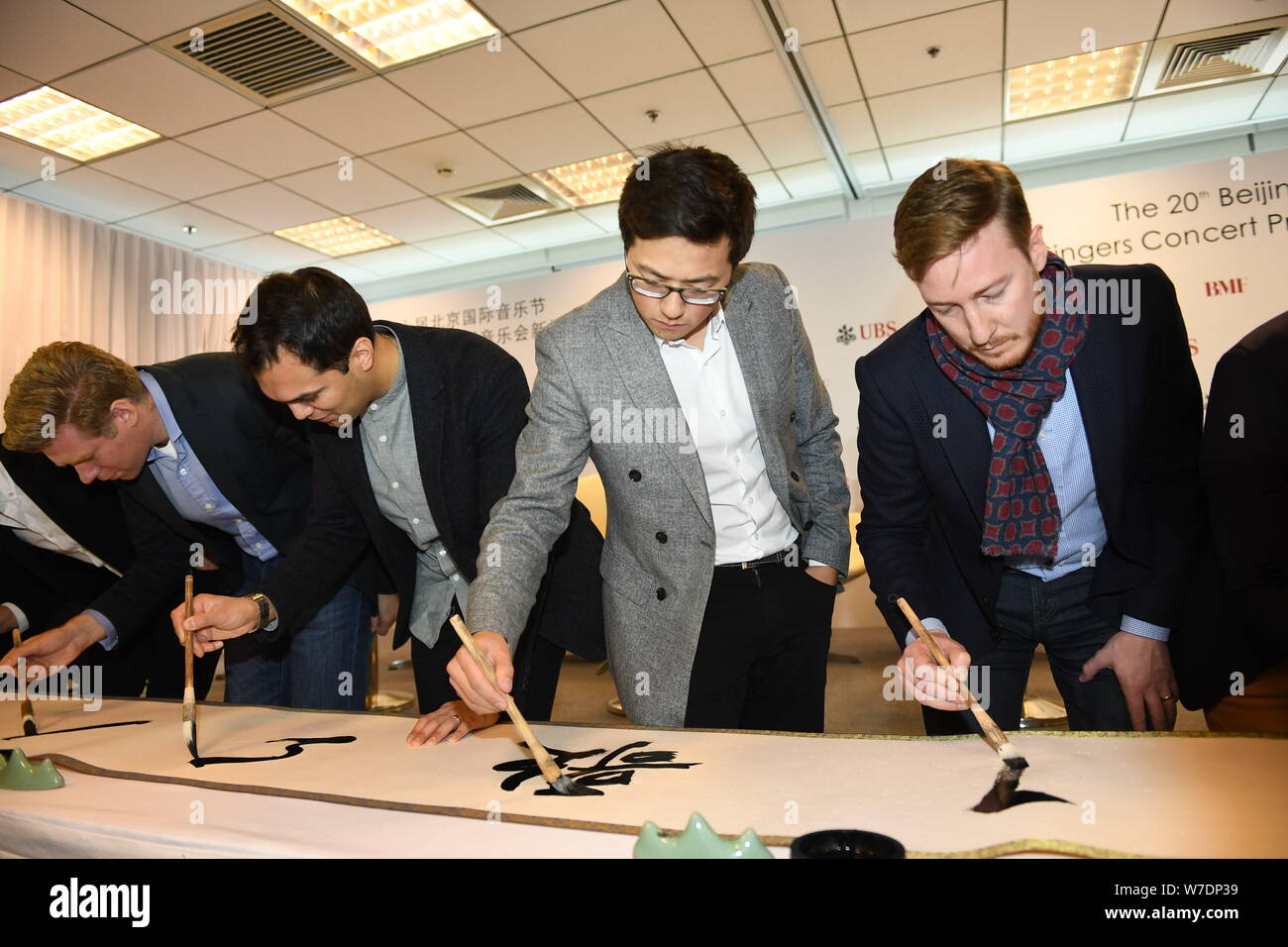 Les membres de l'ensemble vocal britannique King's Singers apprendre à écrire calligraphie chinoise lors d'une conférence de presse au cours de la fête de la musique de Beijing à Bei Banque D'Images