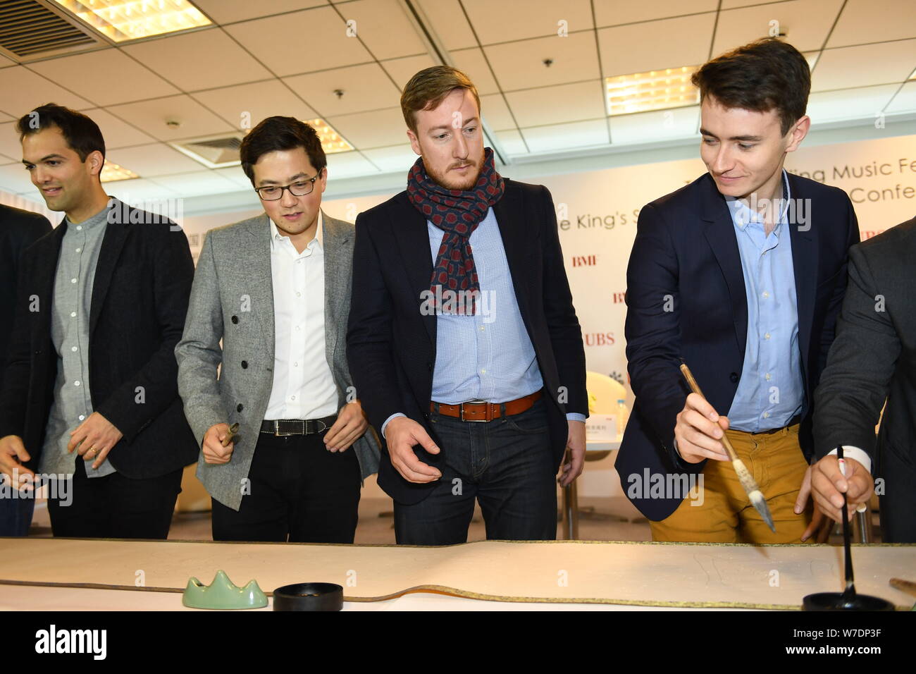 Les membres de l'ensemble vocal britannique King's Singers apprendre à écrire calligraphie chinoise lors d'une conférence de presse au cours de la fête de la musique de Beijing à Bei Banque D'Images