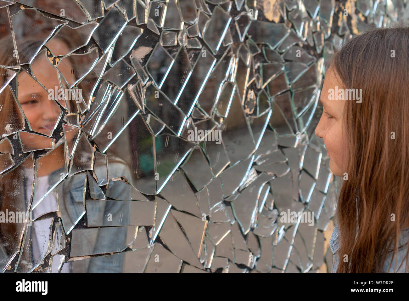Jeune fille lycéenne l'air triste dans le miroir brisé Banque D'Images