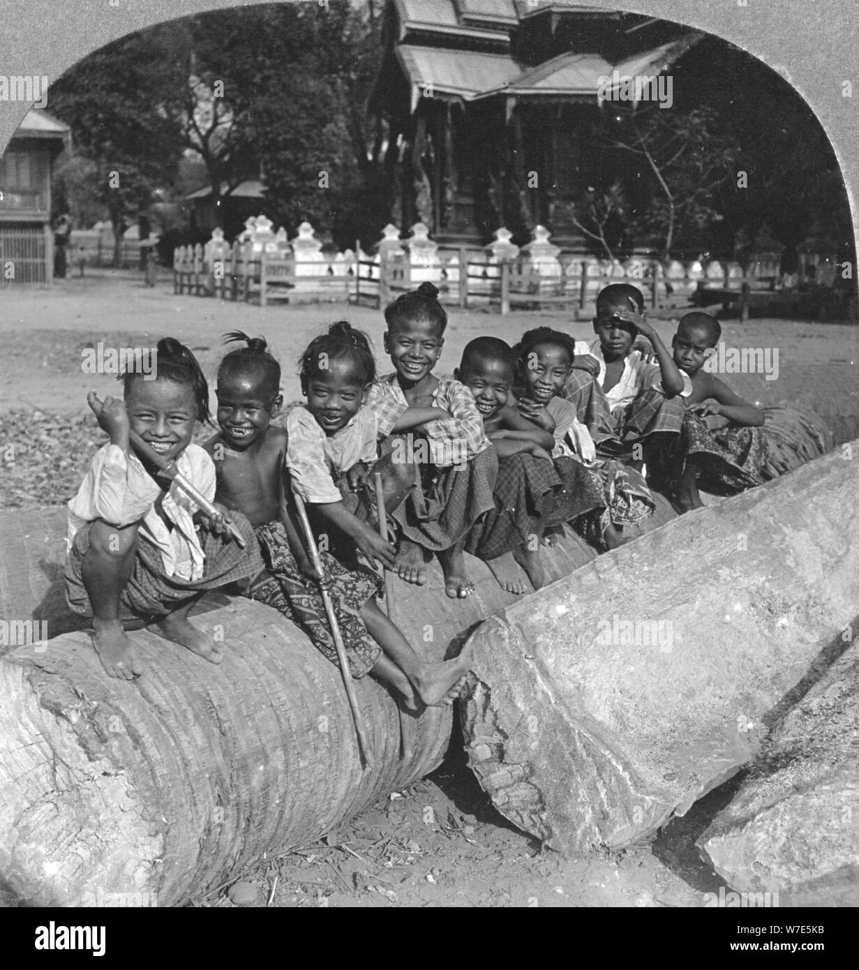 Enfants birmans assis sur un Palm log, Birmanie, 1908. Artiste : Stéréo de Voyage Banque D'Images