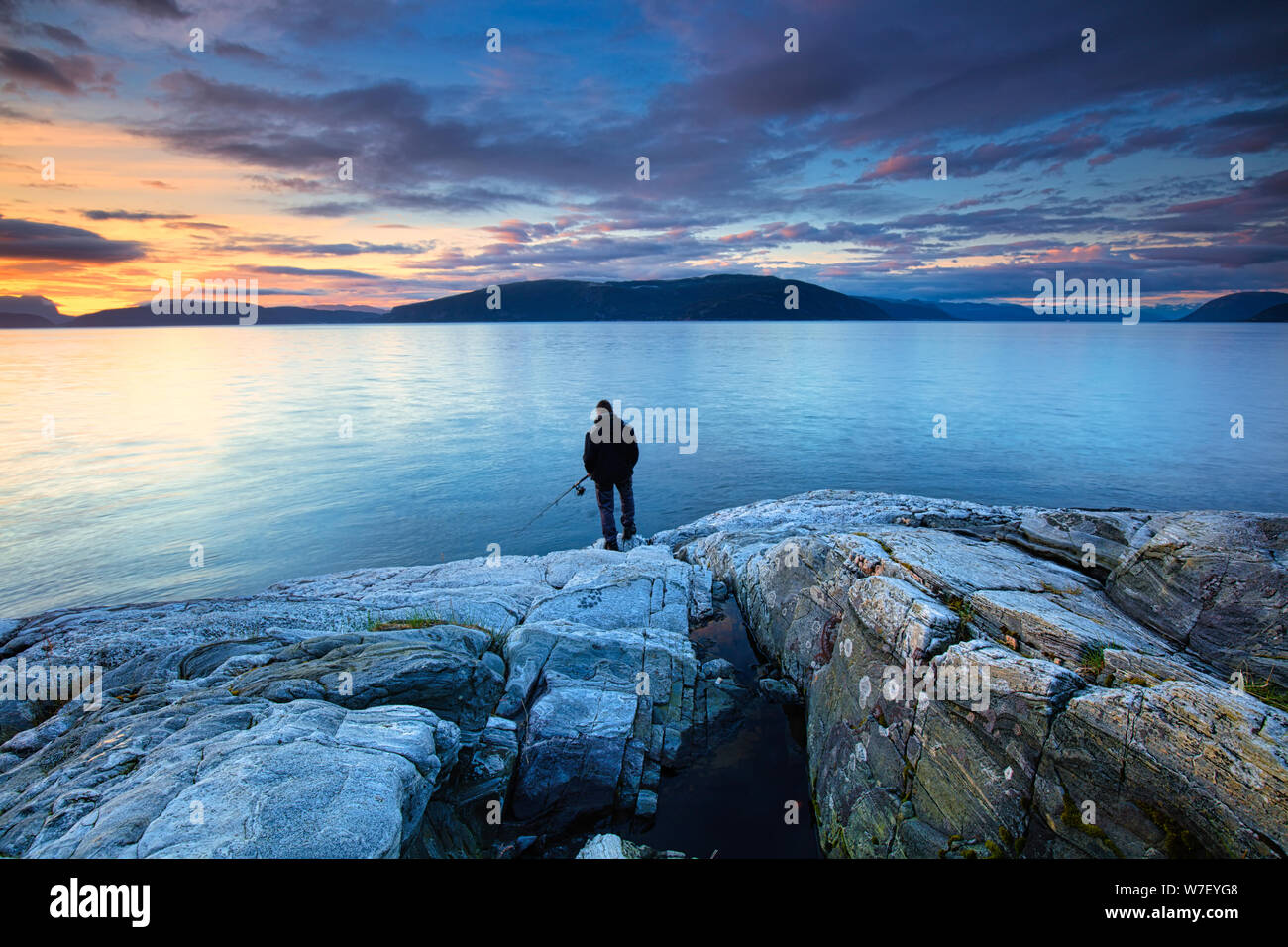 Un pêcheur à la Sogne fjord de la Norvège, d'un beau coucher de soleil avec les montagnes en arrière-plan - image voyage Norvège Banque D'Images