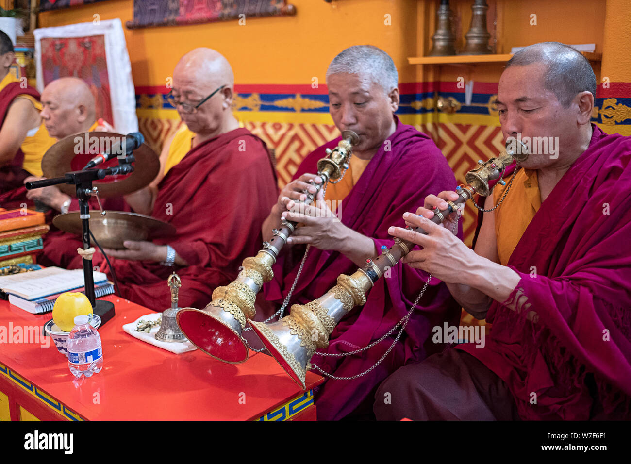 Les moines bouddhistes népalais jouer des instruments traditionnels, y compris l'gyaling horn lors d'une prière publique. Au temple Kyidug Sherpa dans NYC. Banque D'Images
