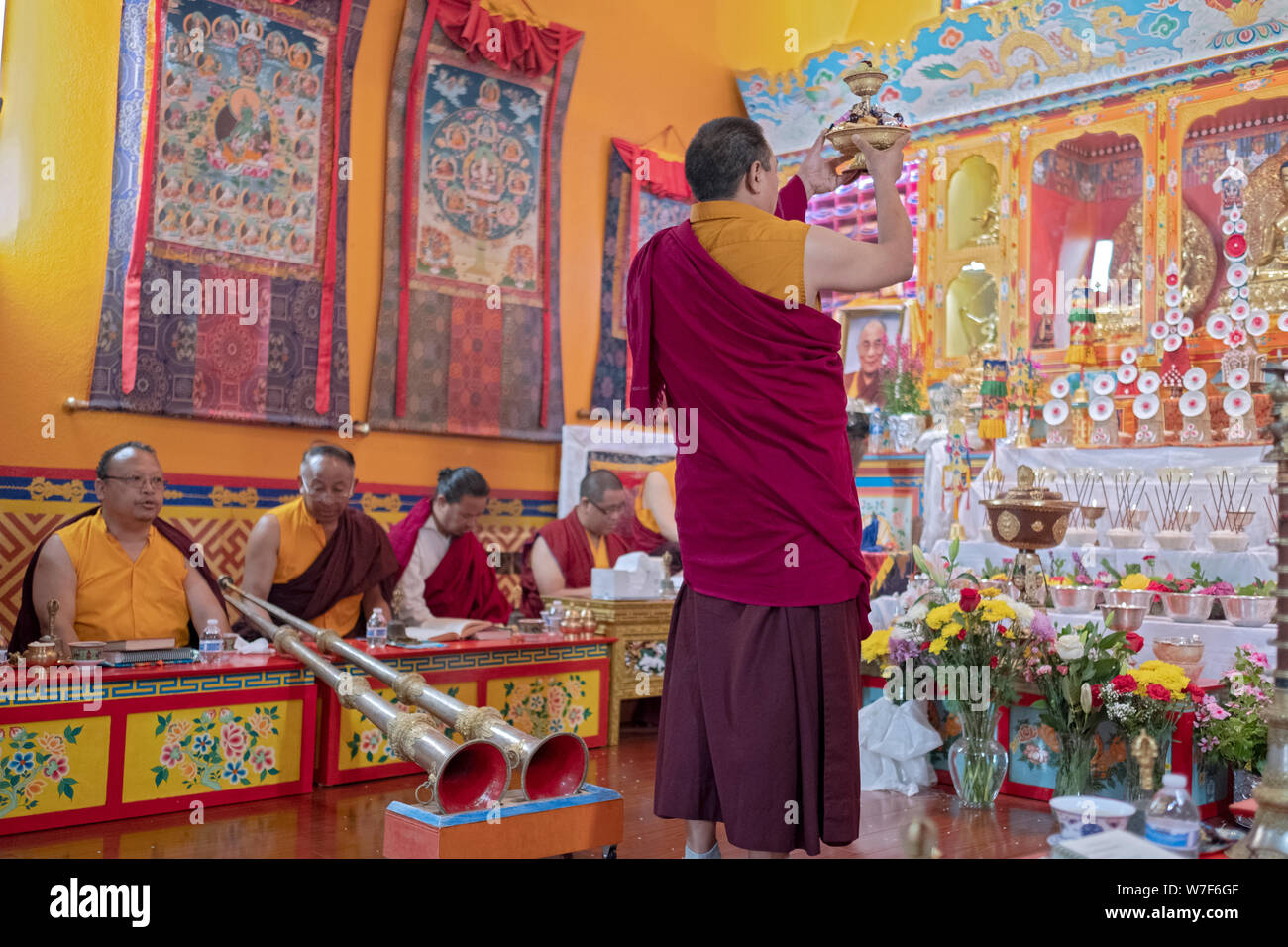 Un moine bouddhiste népalais jouer propose un petit plateau de nourriture au Buddah. Sherpa au temple en Kyidug Elmhurst, Queens, New York. Banque D'Images