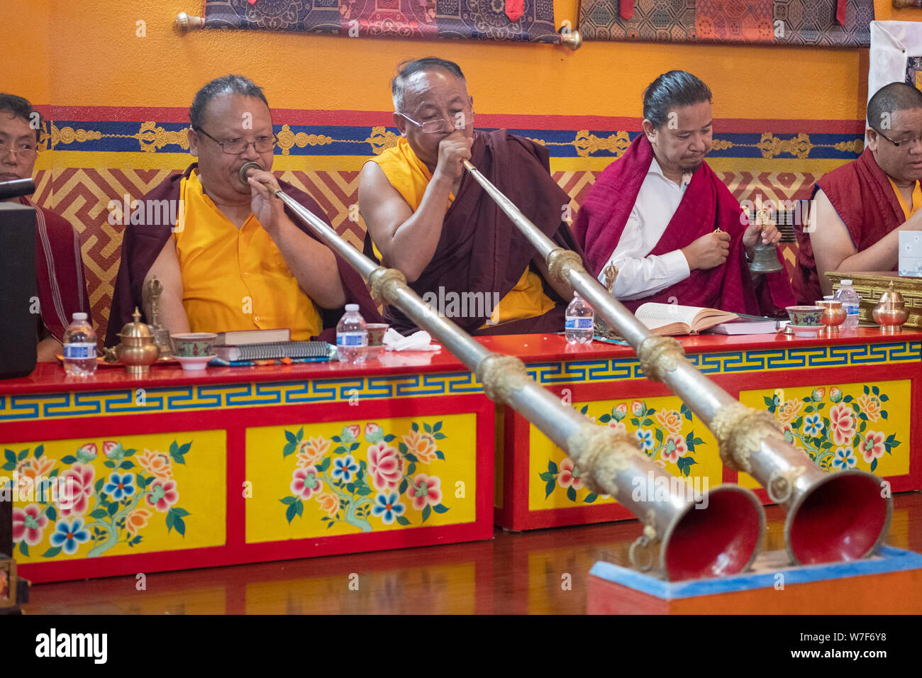 Les moines bouddhistes népalais jouer les dungchen longue corne traditionnels pendant un service de prière. Au temple Kyidug Sherpa dans NYC. Banque D'Images