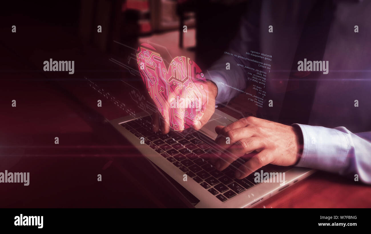 Man typing on laptop avec hologramme coeur cybernétique sur l'écran du clavier. L'amour, cyber dating, romantique, de la santé et de cardiologie concept futuriste. Natu Banque D'Images