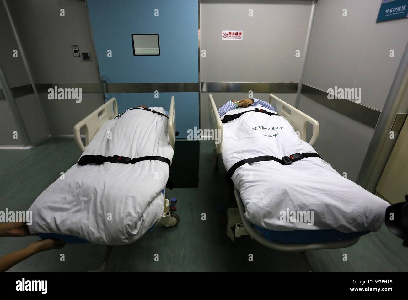 36-year-old Chinese man Yan Wenwu, droite, et sa mère Zhang Xianmei sont vus avant d'accepter une greffe de peau Traitement au First People's Hospital Banque D'Images