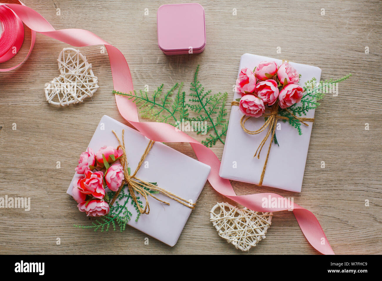 Emballage cadeau écologique. Composition avec boîtes cadeaux décorées de branches vertes et de roses. Banque D'Images