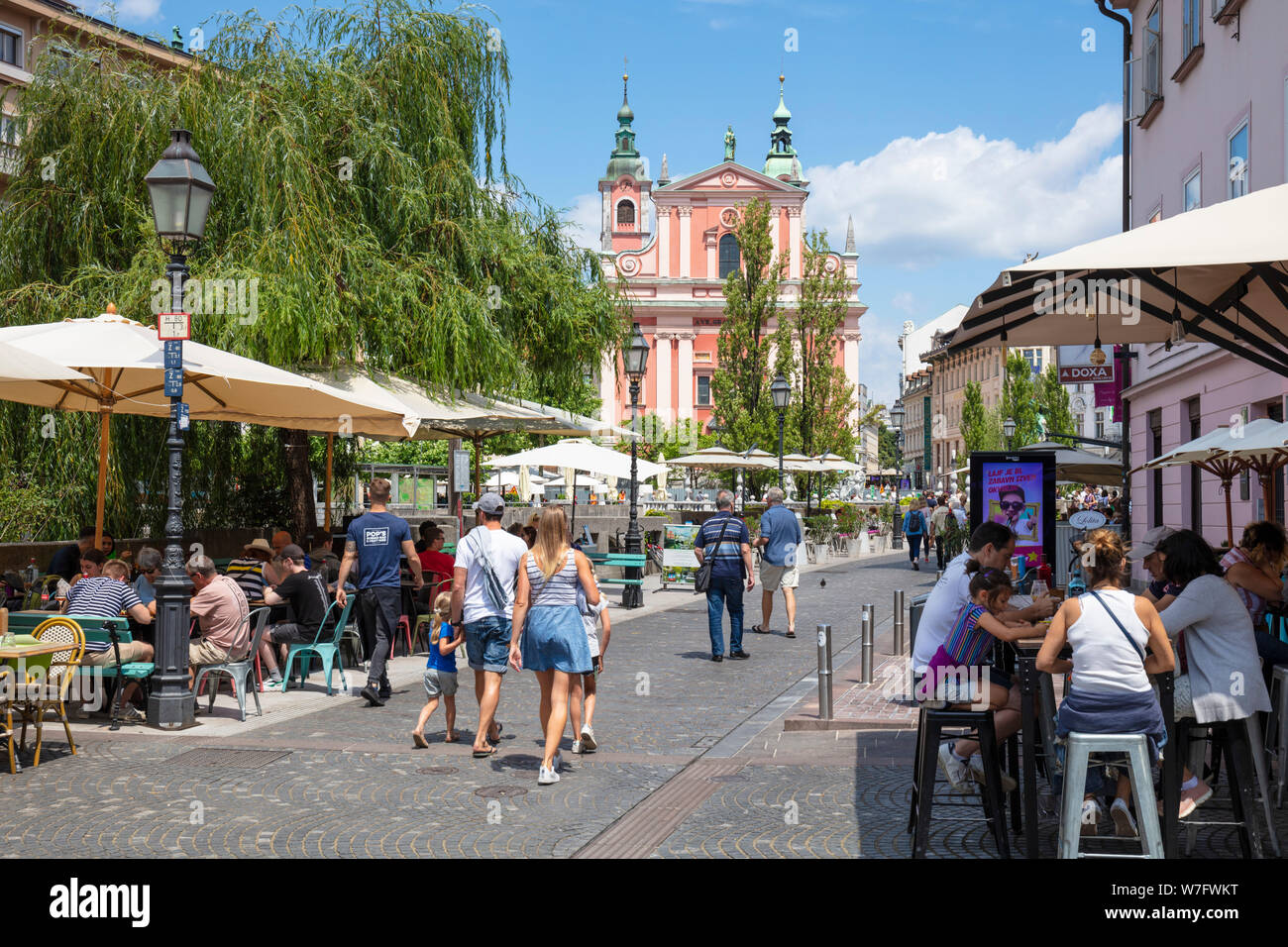 Les touristes à marcher le long de la Cankarjevo nabrežje vers le triple pont cours des cafés sur la promenade Riverside centre de Ljubljana Slovénie eu Europe Banque D'Images
