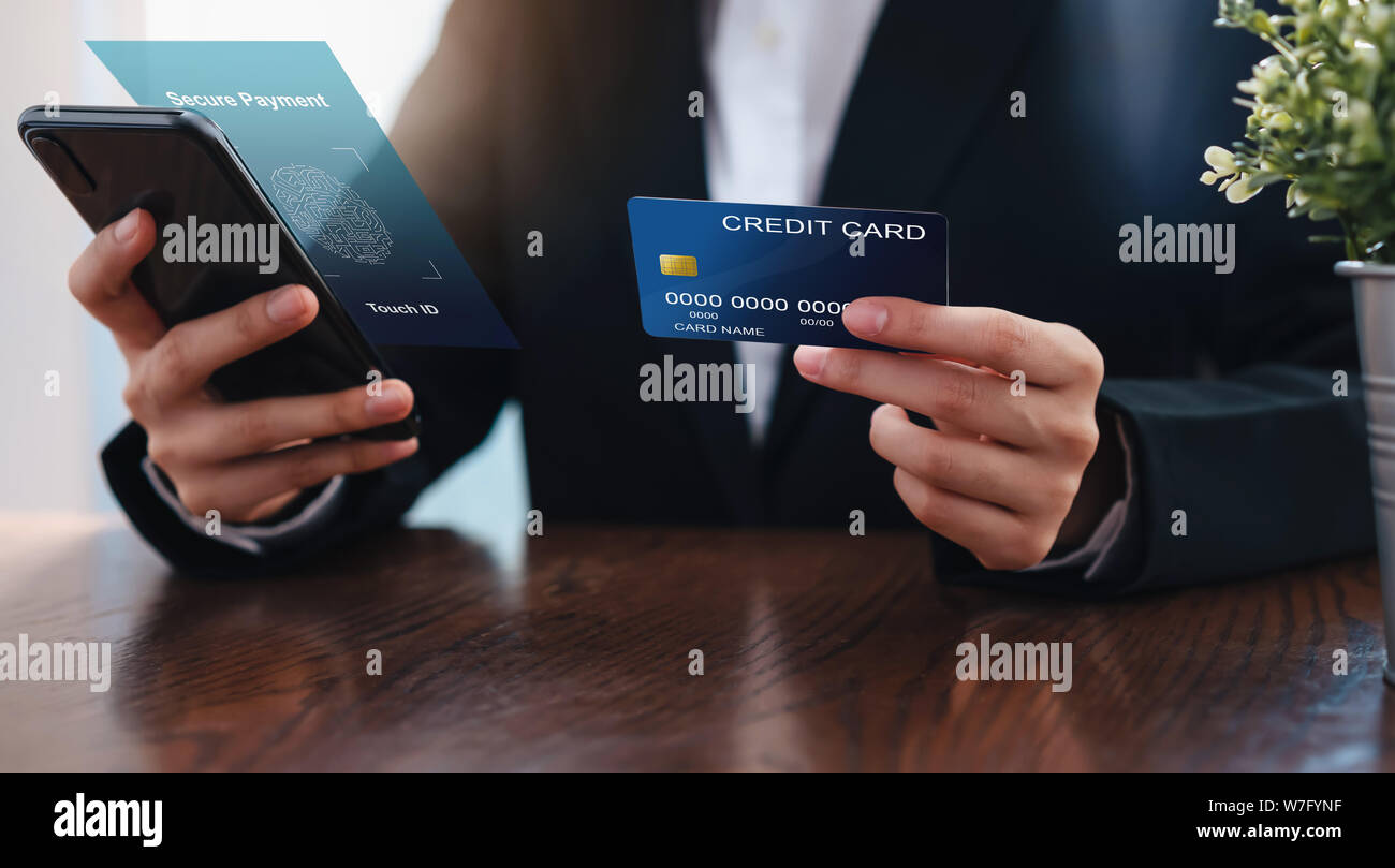 Businesswoman hand holding credit card et smartphone interface Paiement sécurisé avec touch id sur l'application d'avion. Banque D'Images
