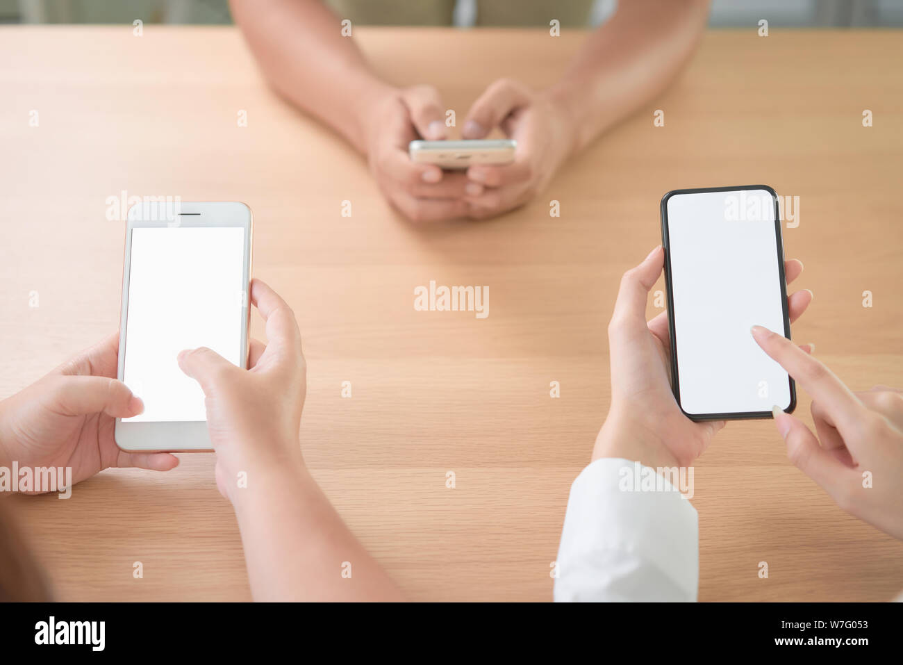 Groupe d'amis holding Smartphone avec écran vide sur la table dans le café. Prenez votre écran pour mettre sur la publicité. Banque D'Images