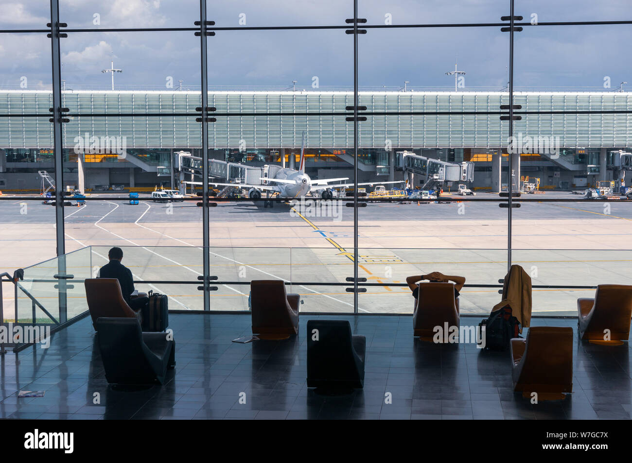 Paris, France, 1 avril 2017 : à la recherche d'une grande fenêtre de l'ellipsoïde à l'aéroport Charles De Gaulle avec deux rangées de chaises en silhouette devant elle. Banque D'Images