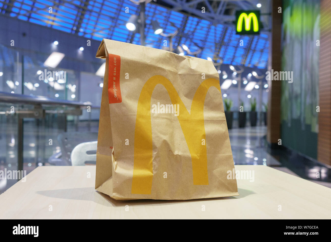 Moscou, Russie - Février 07, 2019 : McDonald's sac en papier brun avec kiosque brouillée dans centre commercial. Banque D'Images