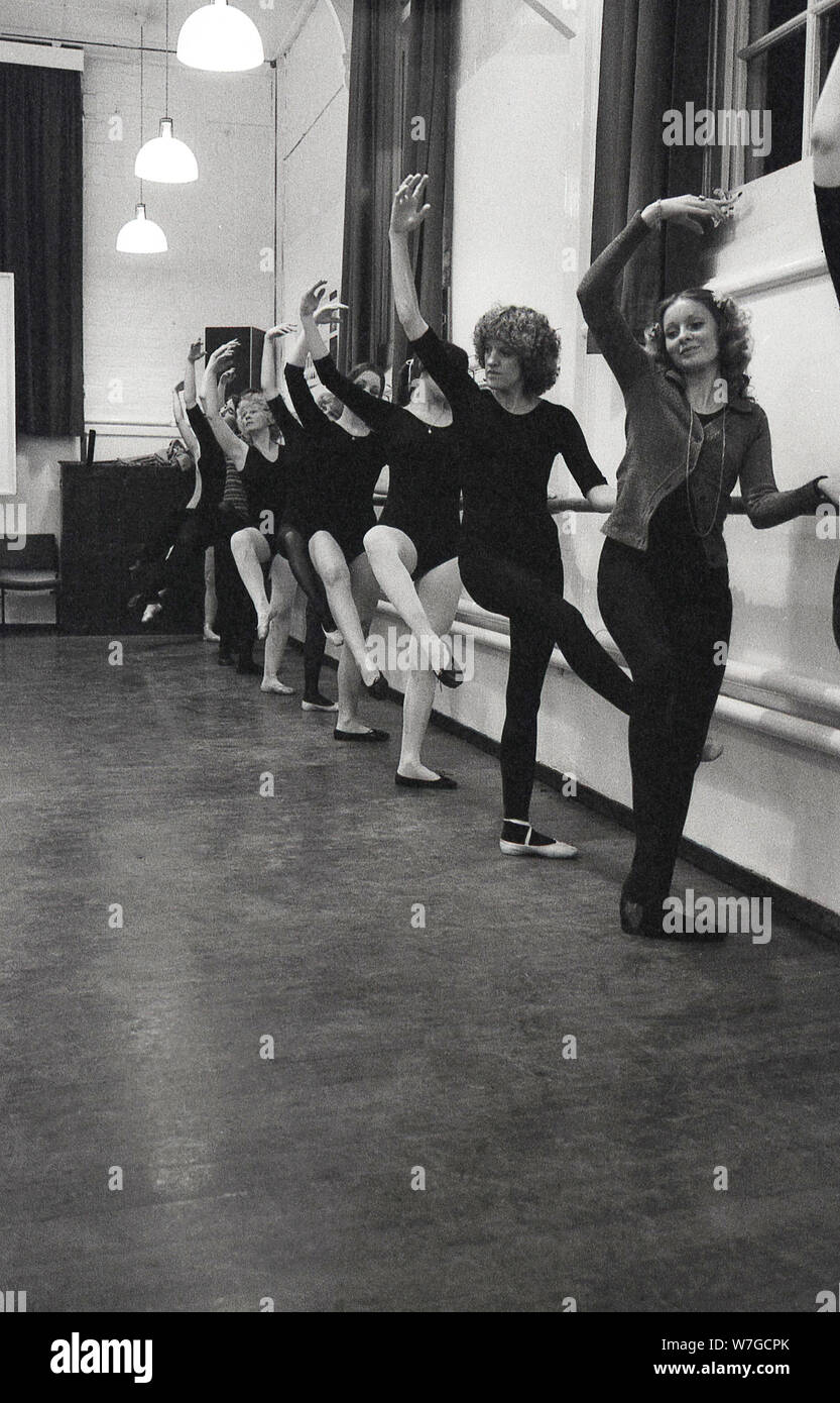 Années 1970, historiques, des profils de ballet, les femmes se tenant à un bar au bord d'un hall d'effectuer des mouvements de danse, England, UK. Banque D'Images
