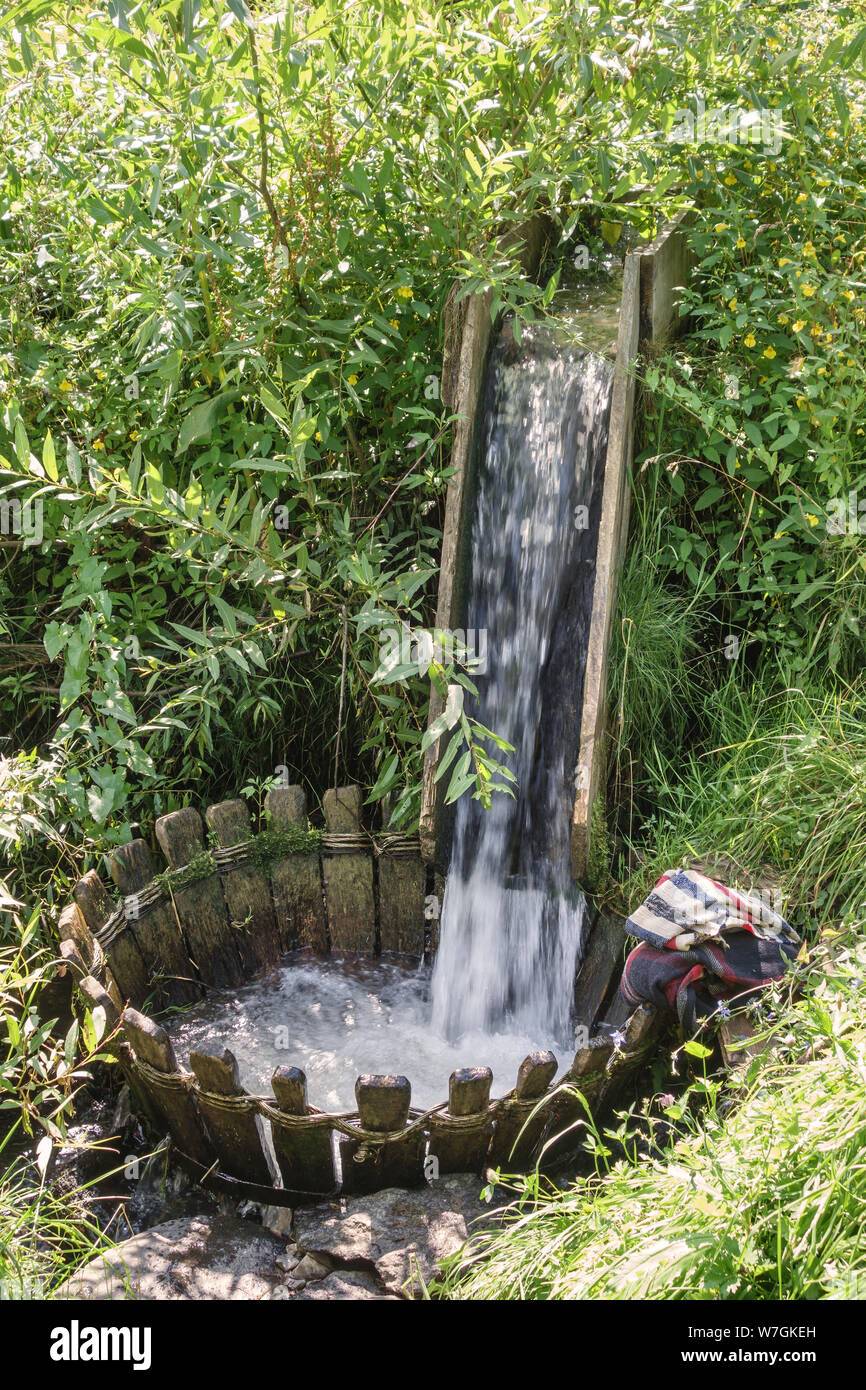 Maramureș, le nord de la Roumanie. Un 'local' whirlpool lave-remous dans le ruisseau qui traverse un village, utilisée pour laver les tapis tissés localement, des couvertures, etc. Banque D'Images