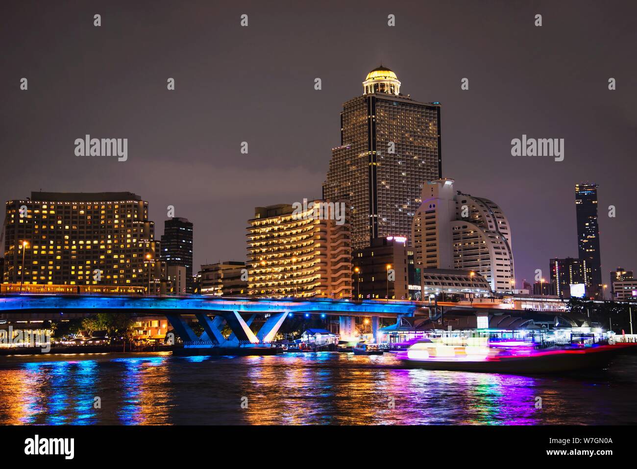 Photo de nuit de la ville asiatique - lumière bleue pont au-dessus de Big River et de l'arrière-plan de construction à Bangkok en Thaïlande Banque D'Images