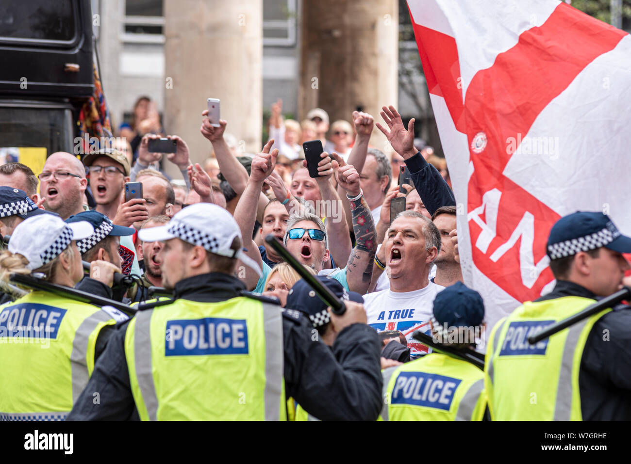 Des foules de gens en colère chez Free Tommy Robinson de protestation à Londres, au Royaume-Uni, derrière le cordon de police. Drapeau de l'Angleterre. Matraque Police soulevé Banque D'Images