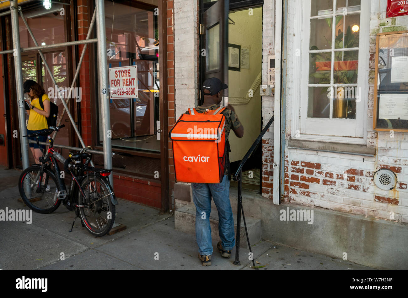 Un travailleur livraison Caviar à l'extérieur d'un bâtiment à New York le Samedi, Août 3, 2019. Square a vendu leur service de livraison de nourriture dans un DoorDash Caviar ot 410 millions $. (© Richard B. Levine) Banque D'Images