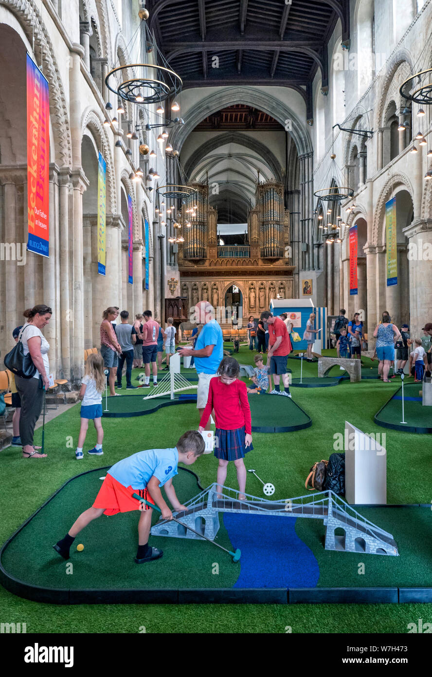 Enfants jouant au minigolf dans la nef de la cathédrale de Rochester Kent UK Banque D'Images