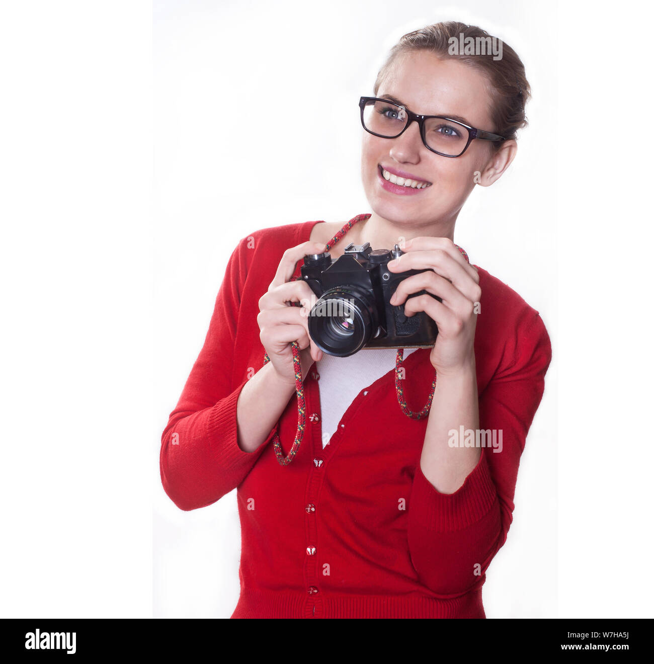 Jeune fille avec un sourire qui se présentent comme des holding vintage camera photographe, sur fond blanc. Banque D'Images