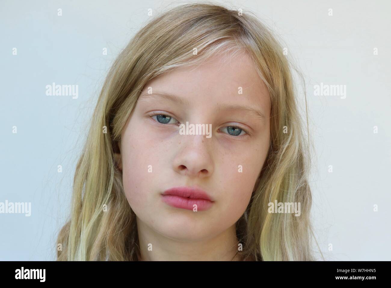 Portrait d'une jeune fille blonde avec un fatigué, déprimé, désespéré regard sur son visage sur un fond blanc. Banque D'Images