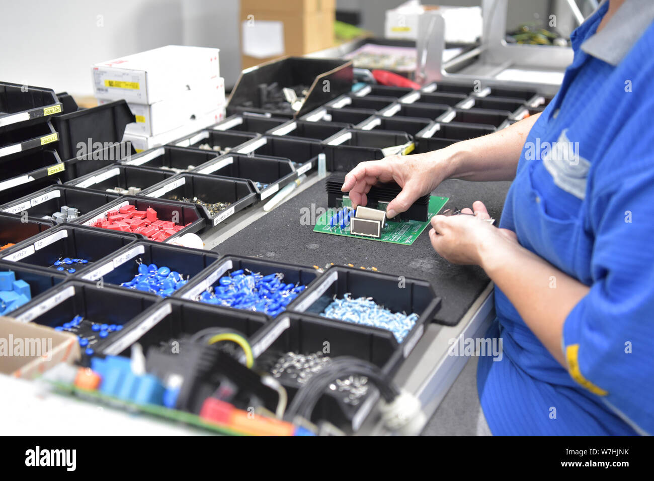 Friendly femme travaillant dans une usine de fabrication de la microélectronique - Montage des composants et la soudure Banque D'Images