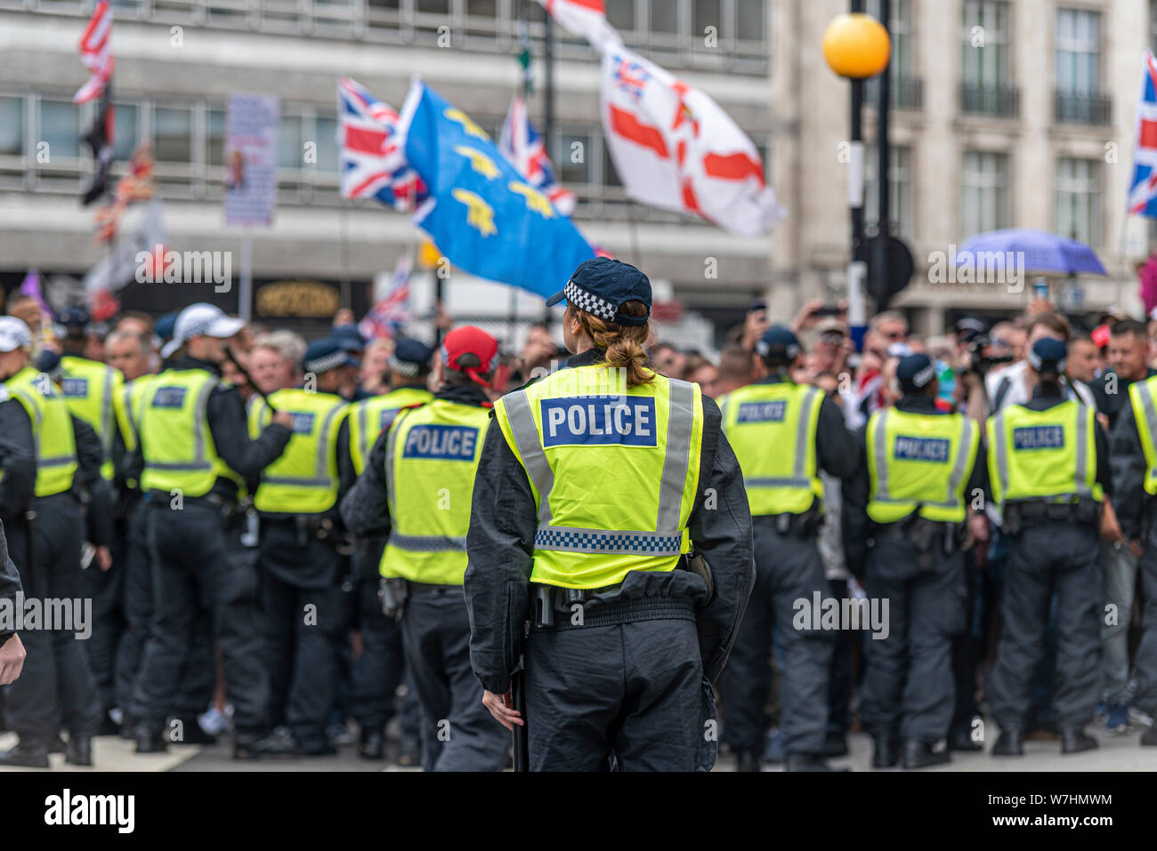 Des foules de gens en colère chez Free Tommy Robinson de protestation à Londres, au Royaume-Uni, derrière le cordon de police. Seule femme séparée des mâles ligne derrière l'agent Banque D'Images