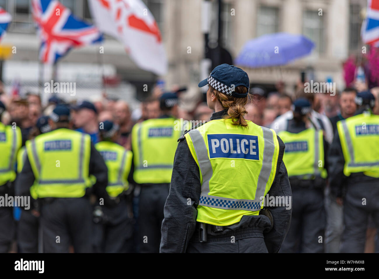 Des foules de gens en colère chez Free Tommy Robinson de protestation à Londres, au Royaume-Uni, derrière le cordon de police. Seule femme séparée des mâles ligne derrière l'agent Banque D'Images