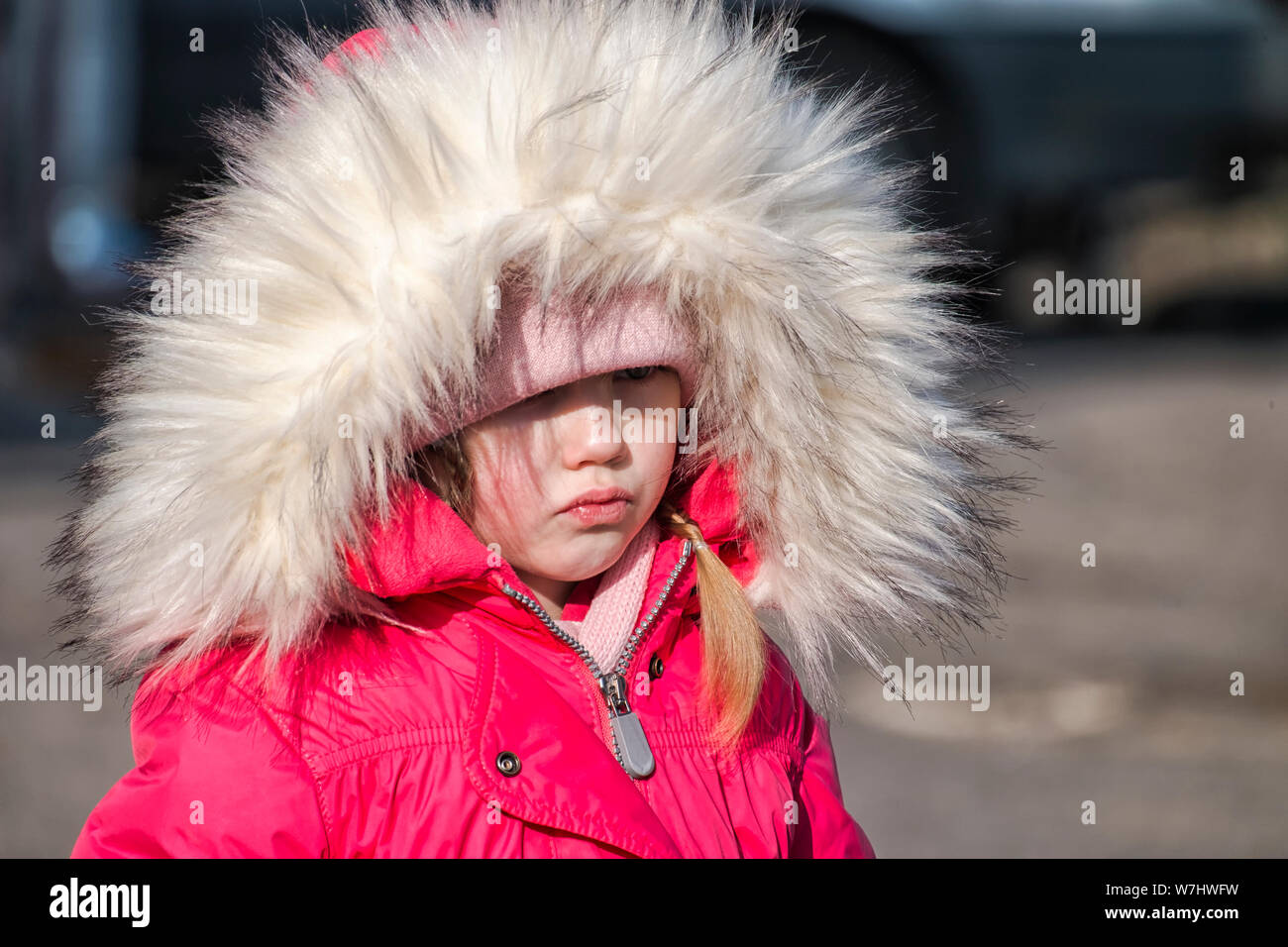 Petite fille dans un dossier rose et lèvres altérées dans une mauvaise humeur Banque D'Images