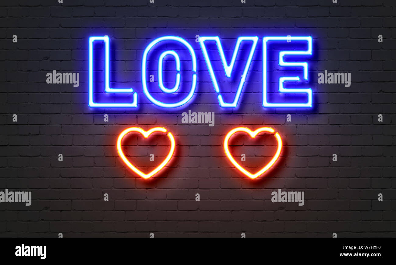 Love neon sign on brick wall background Banque D'Images