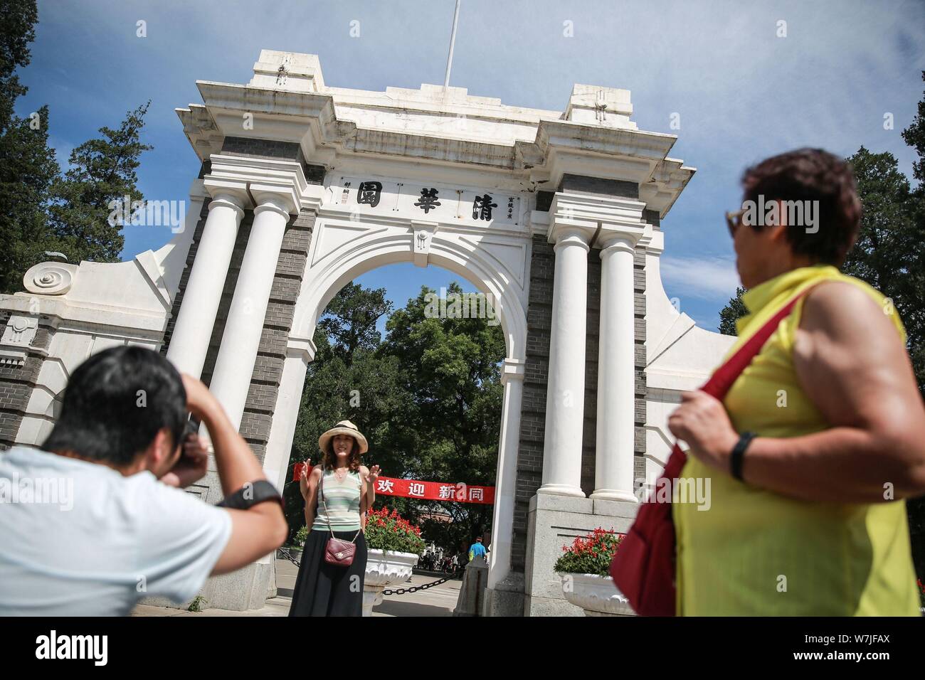 --FILE--un visiteur pose pour des photos en face de la porte de la deuxième symbolique de l'Université de Tsinghua à Pékin, Chine, 25 août 2017. Authoritie chinois Banque D'Images