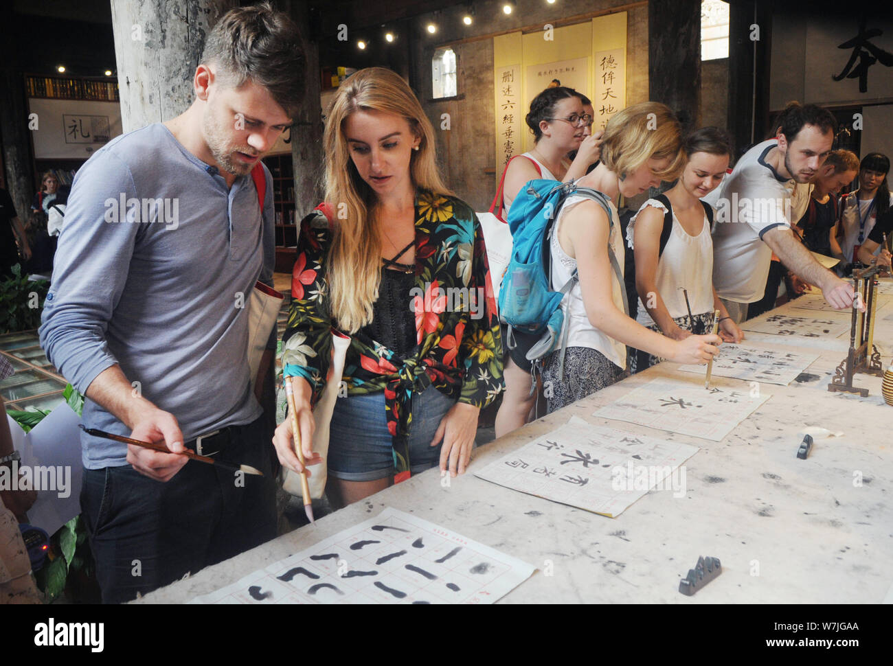 Les étudiants étrangers apprendre à écrire calligraphie chinoise au cours d'une activité au village, Shangjing Tangxi ville, dans la ville de Jinhua, East China's Zhejiang bauvin Banque D'Images