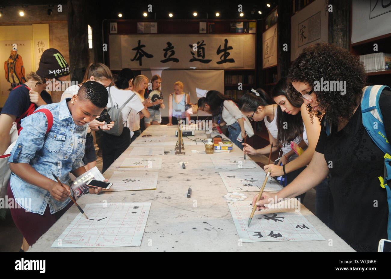 Les étudiants étrangers apprendre à écrire calligraphie chinoise au cours d'une activité au village, Shangjing Tangxi ville, dans la ville de Jinhua, East China's Zhejiang bauvin Banque D'Images