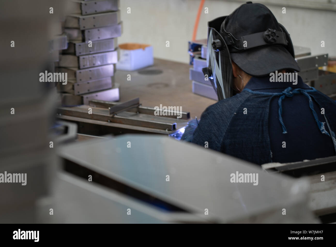 Chinese man welding metal composants dans une usine en Chine près de Shanghai, Chine. Banque D'Images