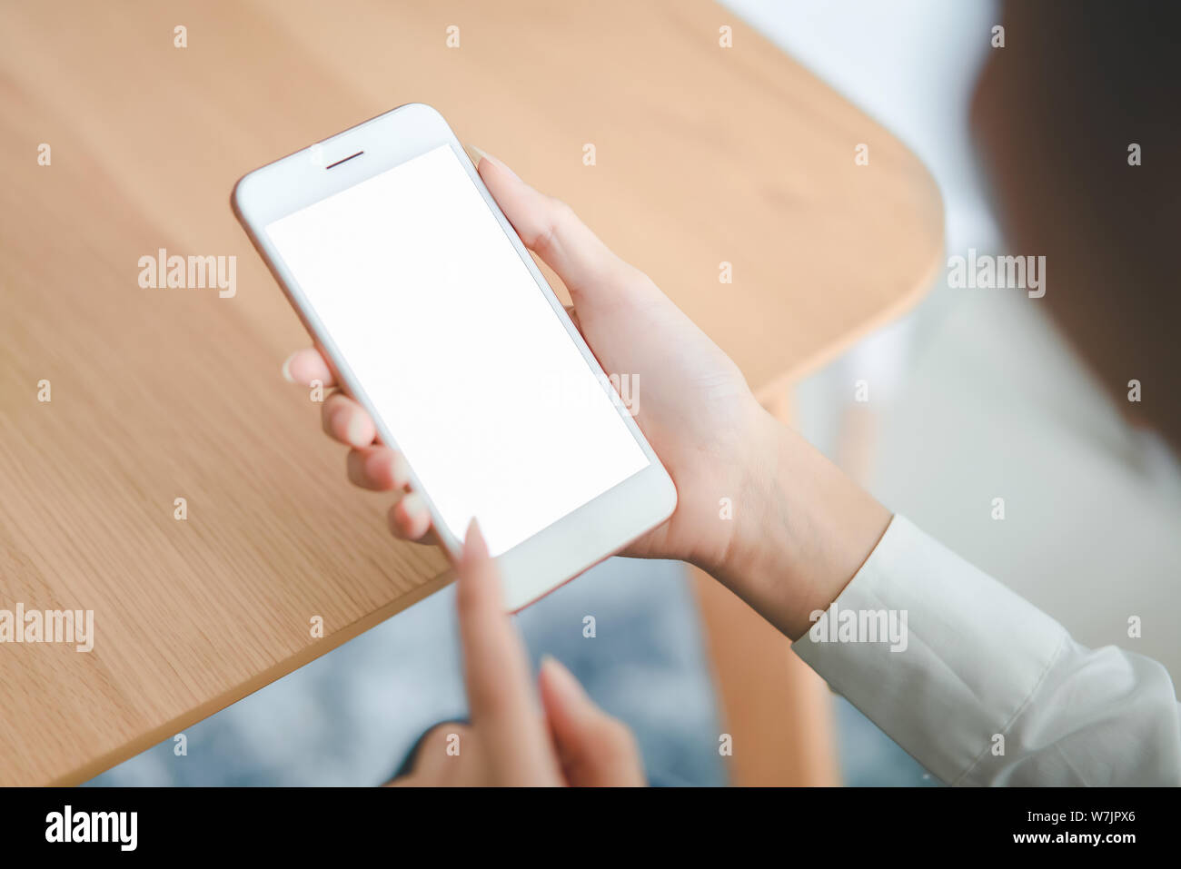 Woman holding Smartphone avec écran vide sur la table dans le café. Prenez votre écran pour mettre sur la publicité. Banque D'Images