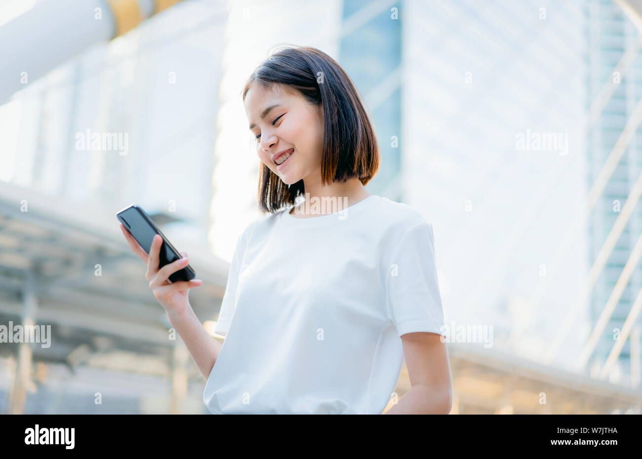 Les femmes asiatiques de happy smiling et utilisation smartphone.Le concept d'utiliser le téléphone est essentiel dans la vie quotidienne. Banque D'Images