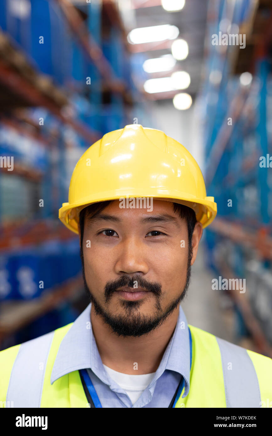Asian male worker looking at camera in warehouse Banque D'Images