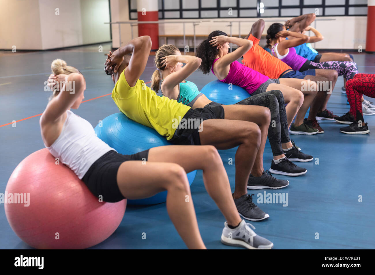 Les formateurs formation des personnes pour exécuter yoga sur boule d'exercice Banque D'Images
