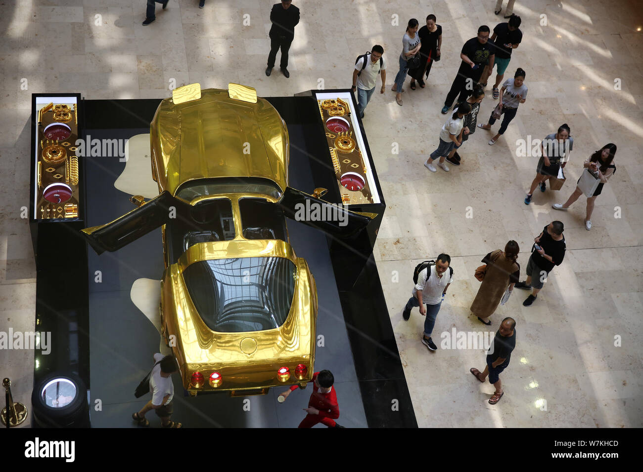 Les gens regardent une voiture de sport d'or s'affiche à Cartier ''quand l'ordinaire devient Preciousn'' exposition dans la région de la ville de Nanjing Xinjiekou, Banque D'Images