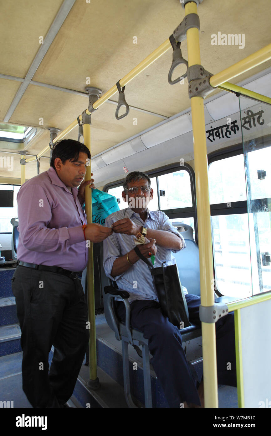 Bus conductor giving ticket to passenger Photo Stock - Alamy