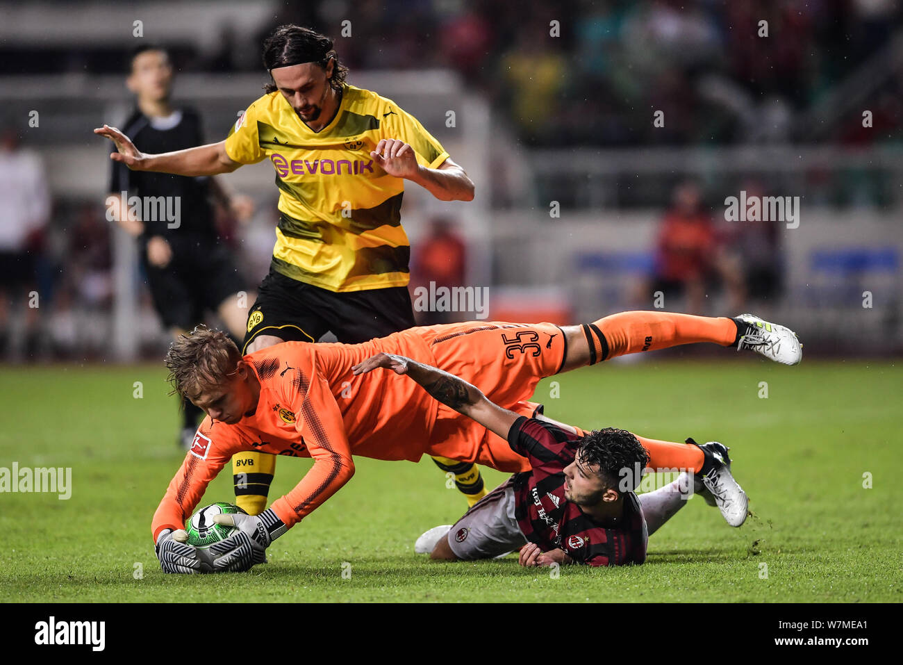 Le gardien de but allemand Dominik Reimann de du Borussia Dortmund, centre, enregistre la balle contre l'AC Milan au cours de la correspondance de Guangzhou de l'International 2017 Banque D'Images