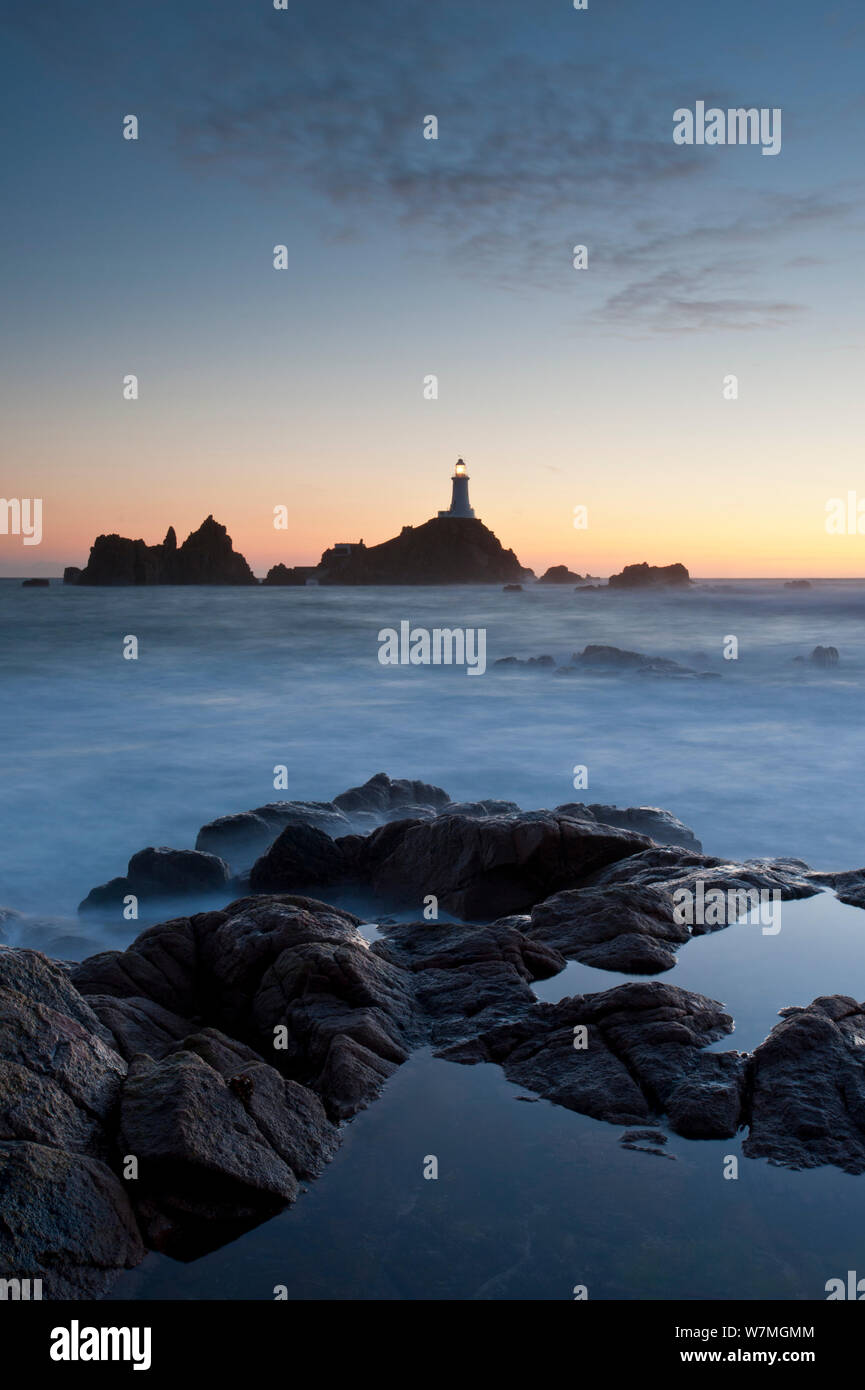 Vue sur le coucher du soleil de la Corbiere lighthouse situé à l'extrême sud-ouest de Jersey, St Brelade) Jersey, Îles Anglo-Normandes, Royaume-Uni, septembre 2011. Banque D'Images