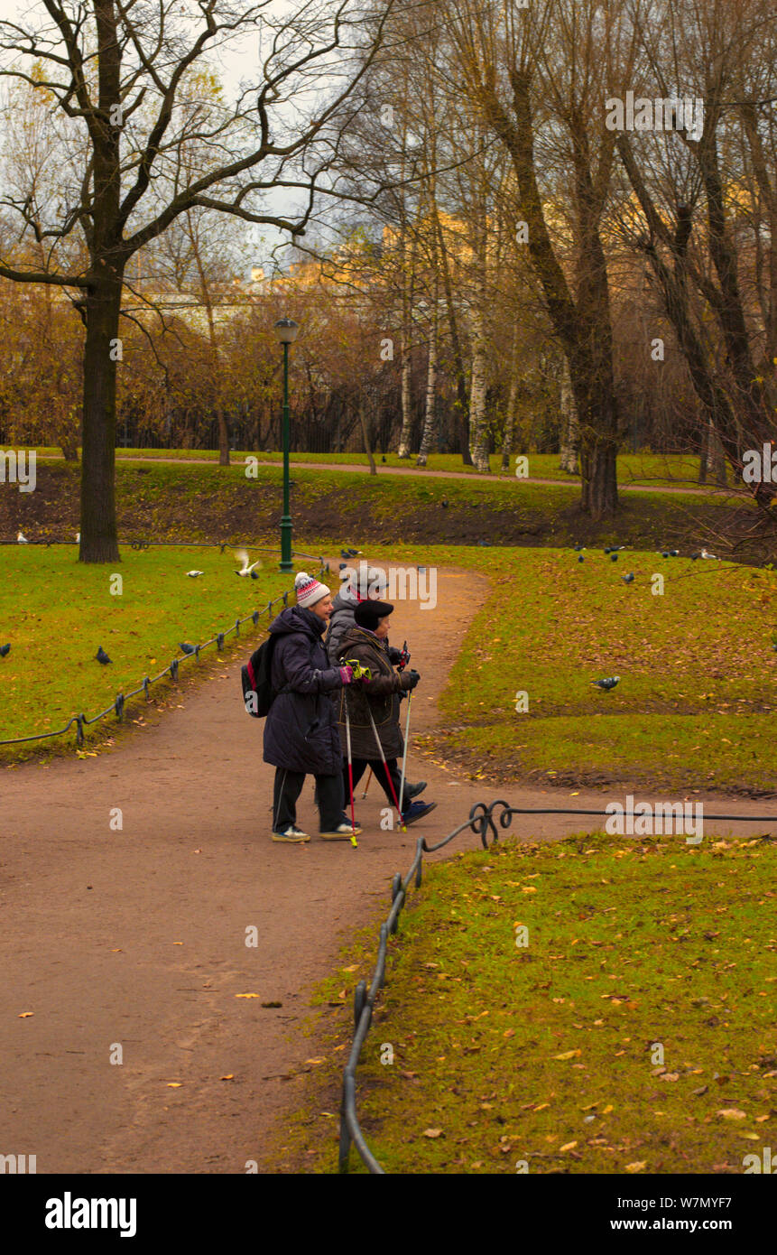 Saint Petersburg, Russie - 16 novembre 2018 : Trois personnes âgées engagées dans la marche nordique dans le parc sur un jour nuageux en fin d'automne Banque D'Images