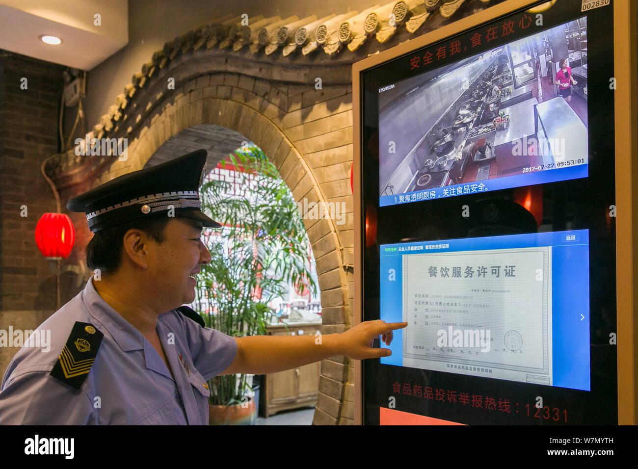 Un personnel de la Food and Drug Administration vérifie la licence de service de restauration affichée à l'écran d'un terminal intelligent de le voir-à travers Banque D'Images